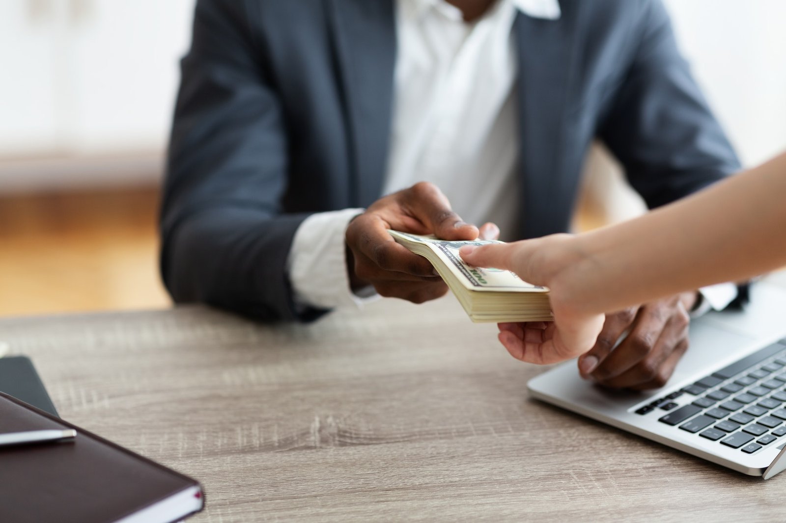 Unrecognizable black businessman accepting bribe from client, sealing the deal